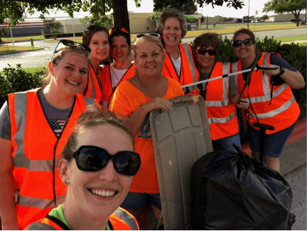 Group of women in orange vests, ready to pick up trash