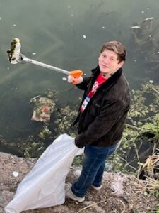 2023 DMWT6 young man holds up litter with his litter grabber at a waterways cleanup