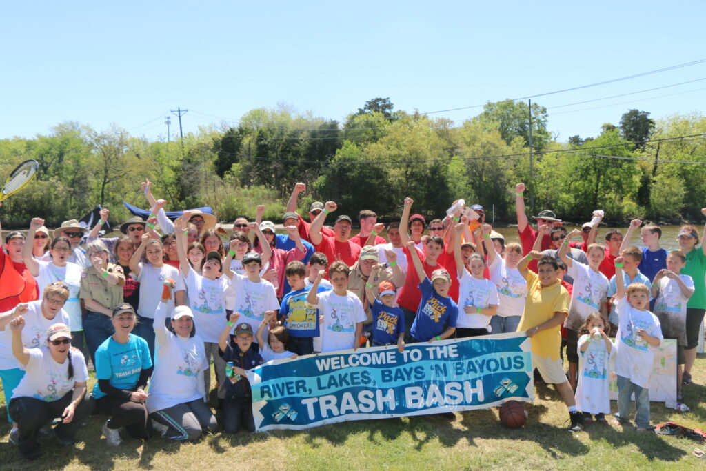 Photo of Dickinson Waterway cleanup volunteers holding a banner with the words "Trash Bash"