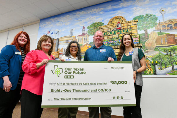 representatives from KTB, the city of Floresville, and H-E-B pose with a presentation check celebrating the grant awards to the city of Floresville to open a new recycling center